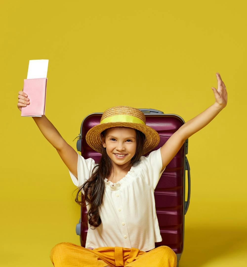 A child holding a flight ticket and passport with hands in the air