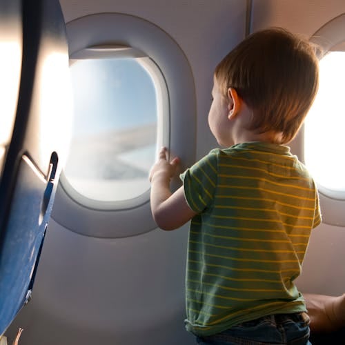 A toddler looking out a plane window