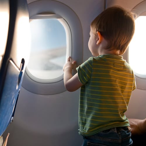 A toddler looking out a plane window