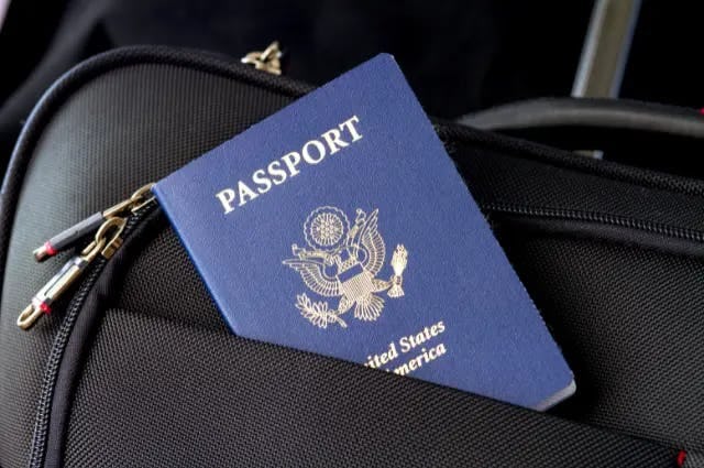 A passport sticking out of a bag pocket