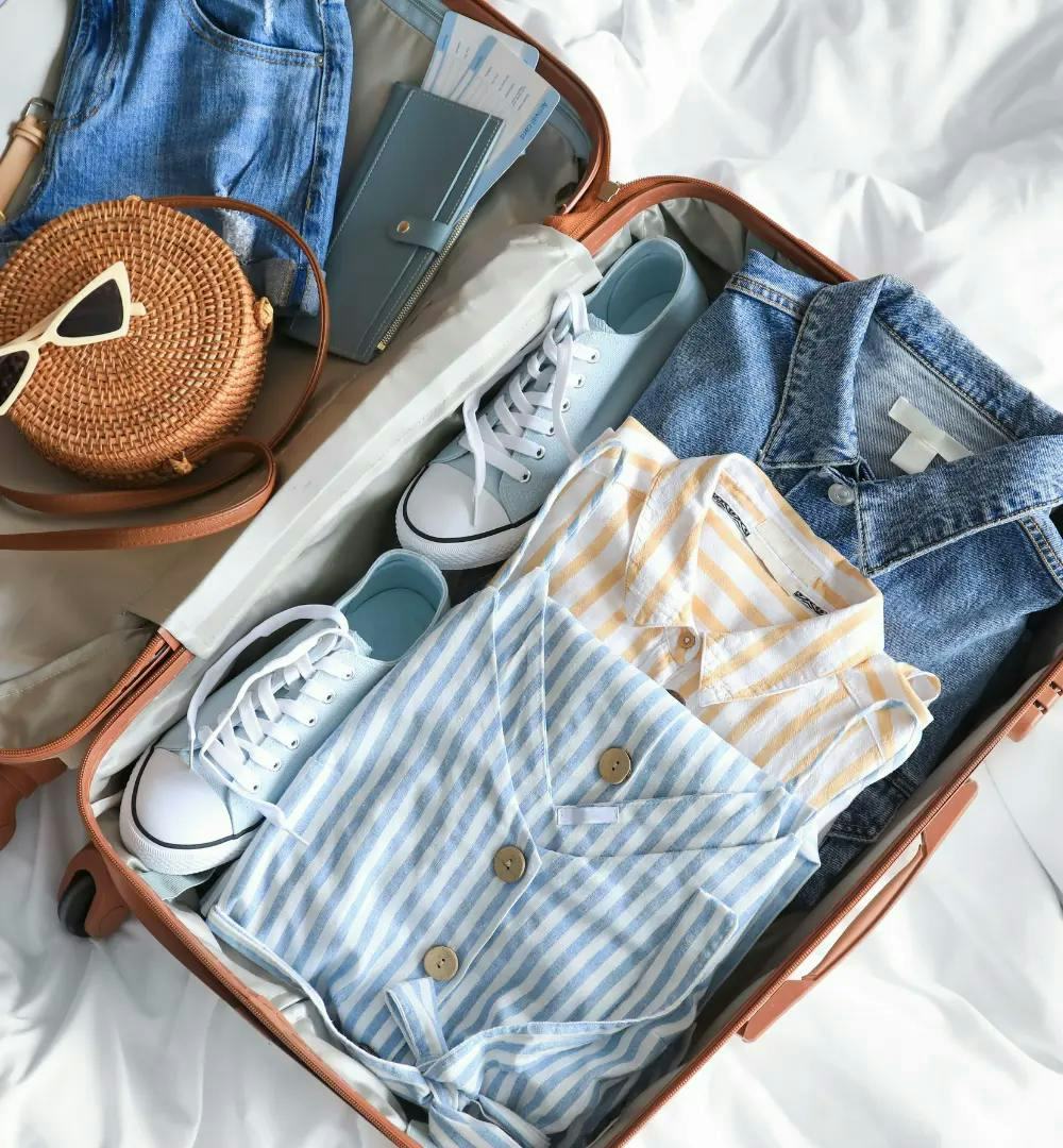 An open suitcase with clothes and shoes inside