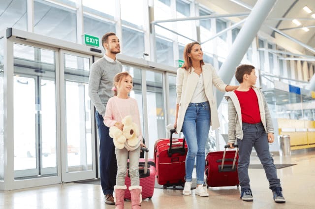 family arriving to the airport with bags