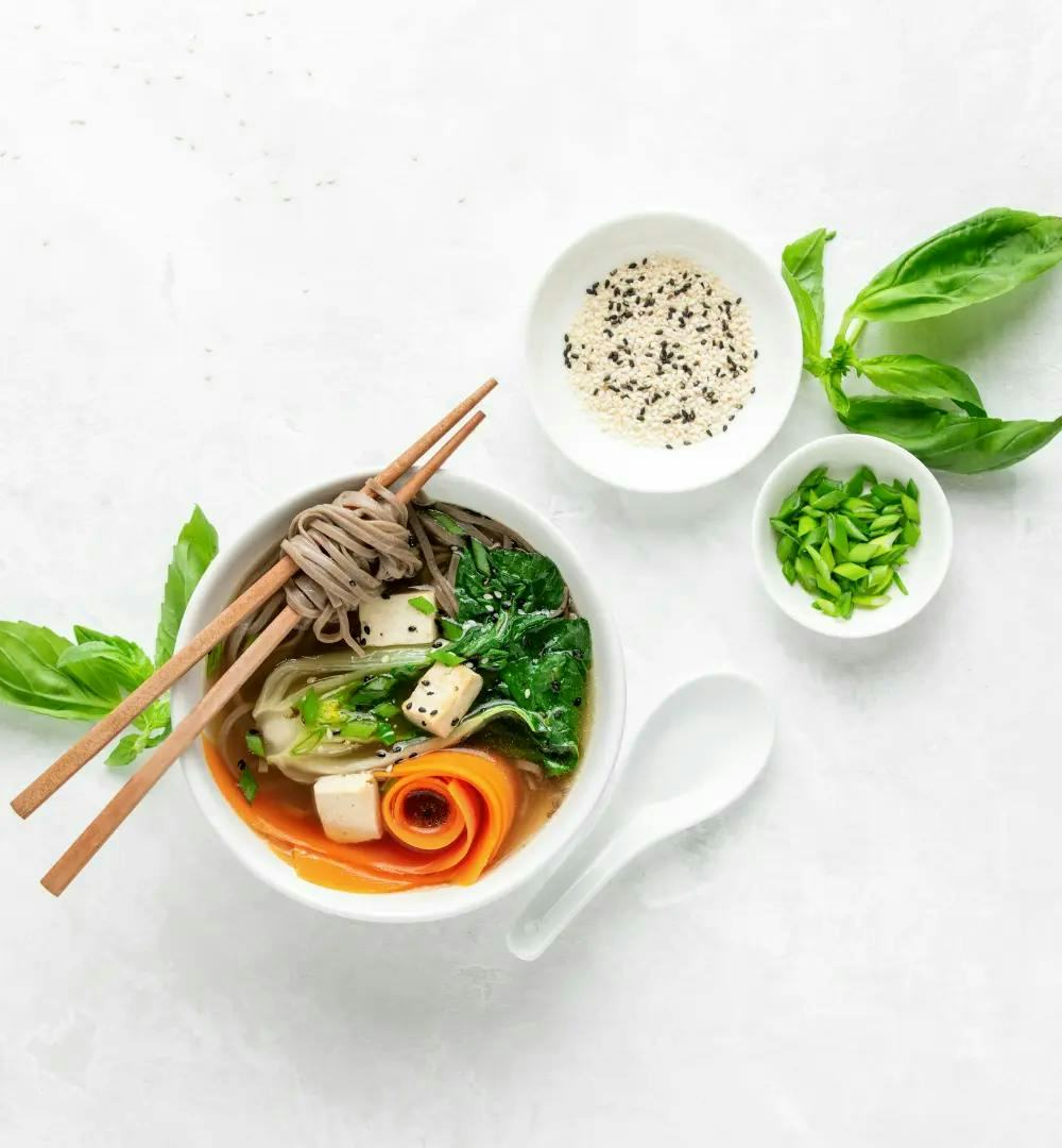 Udon noodle soup with chopsticks on a white background