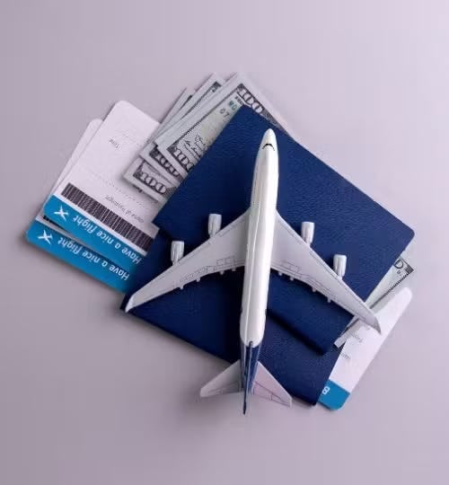 A model plane on top of a passport and plane tickets