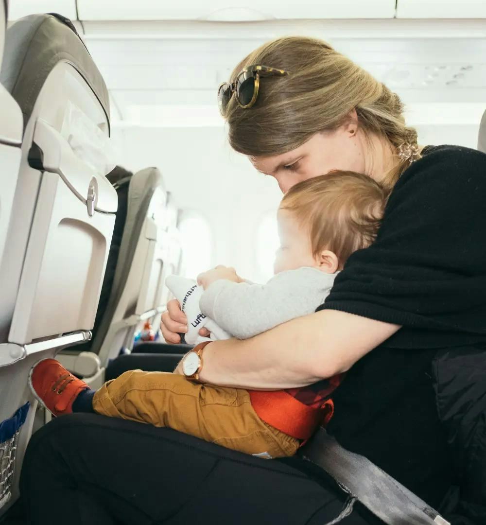 baby on woman's lap on aeroplane