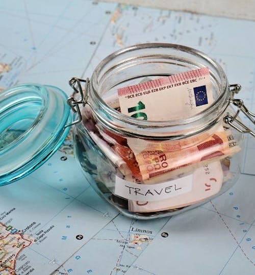 Cash inside a glass jar on a map