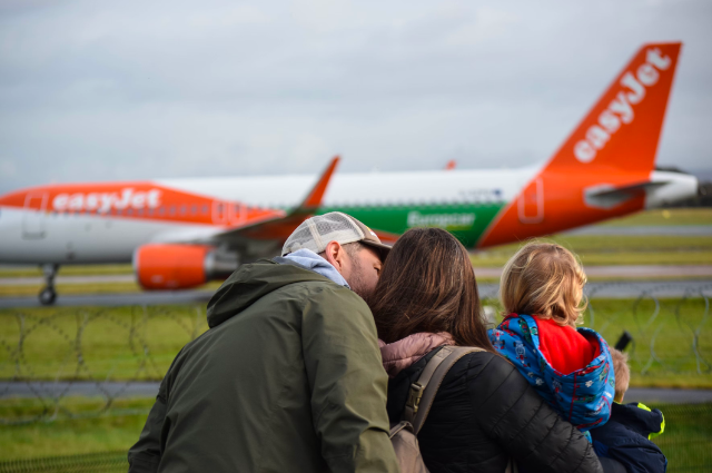 Father, mother and child looking at an easyJet aircraft