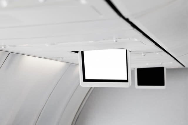 A close up shot of an in-flight entertainment system on the ceiling of a plane
