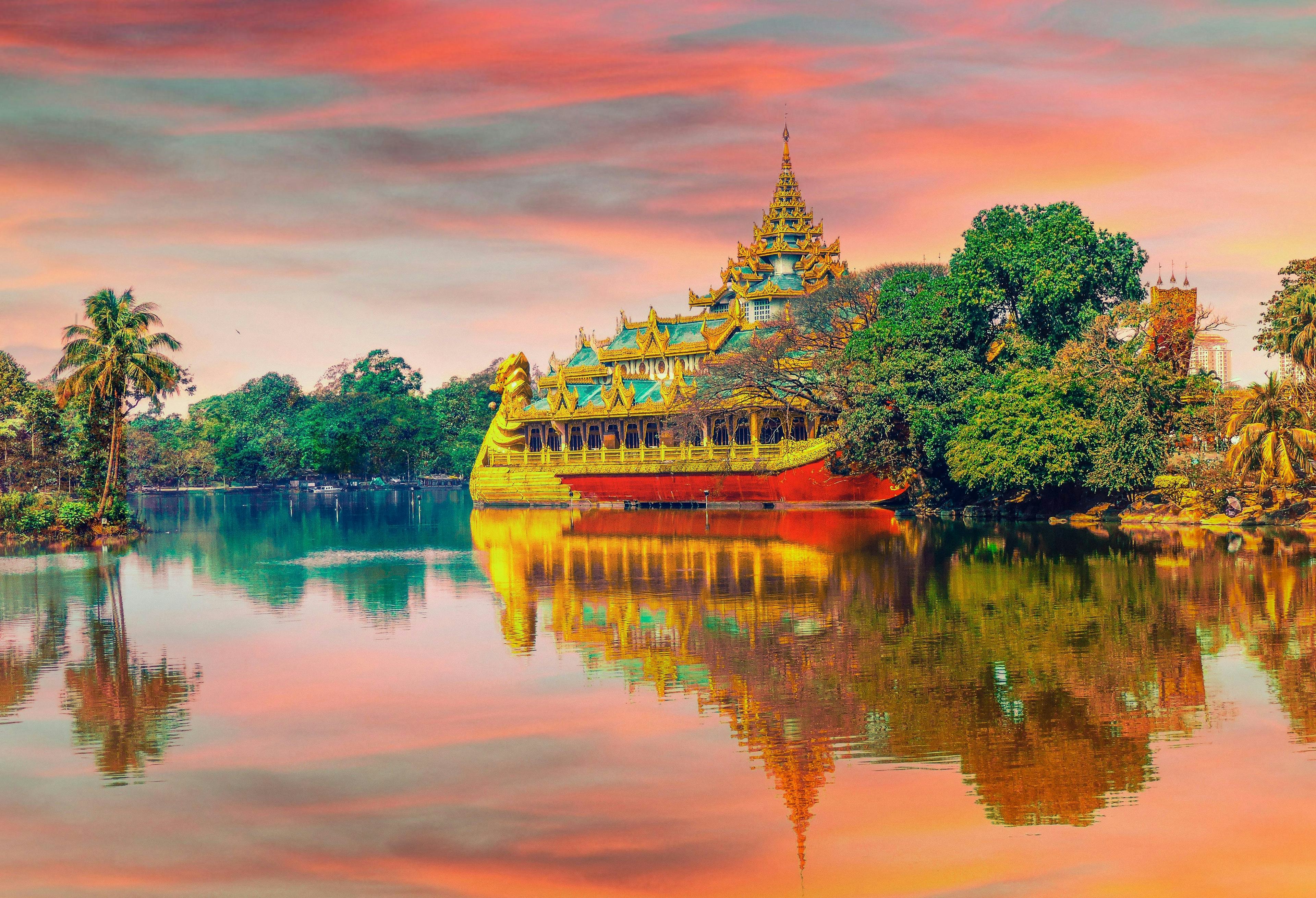 A traditional and ornate thai building on the banks of a river 
