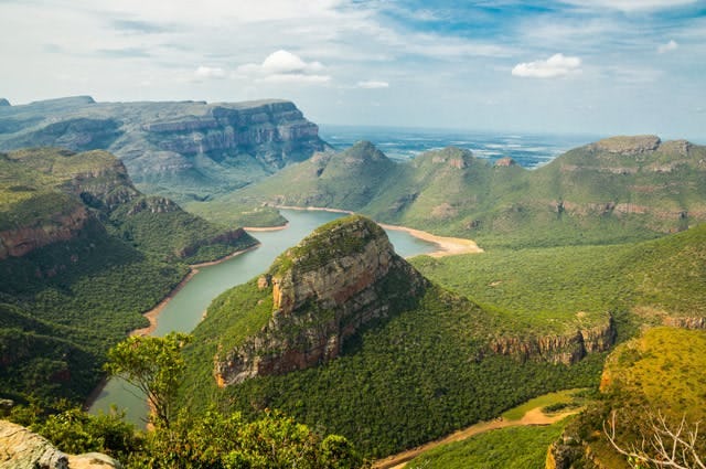 A green mountain range cut down the middle with a winding river in South Africa 