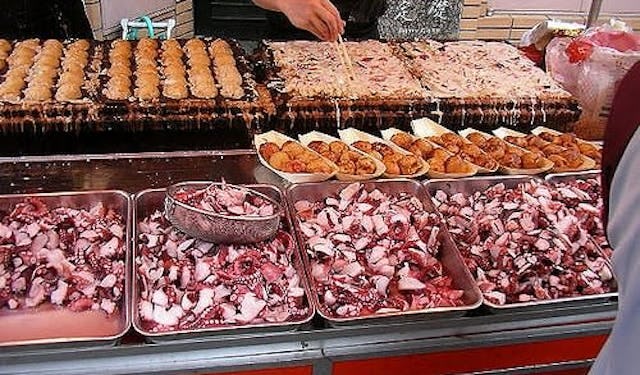 A street food vendor's stall, with piles of seafood available 