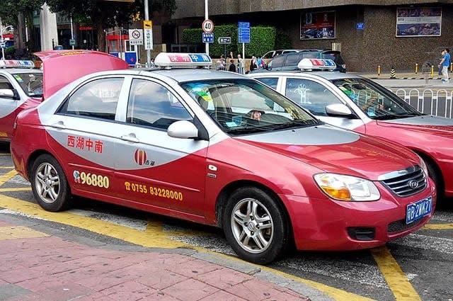 A red and silver Shenzhen taxi