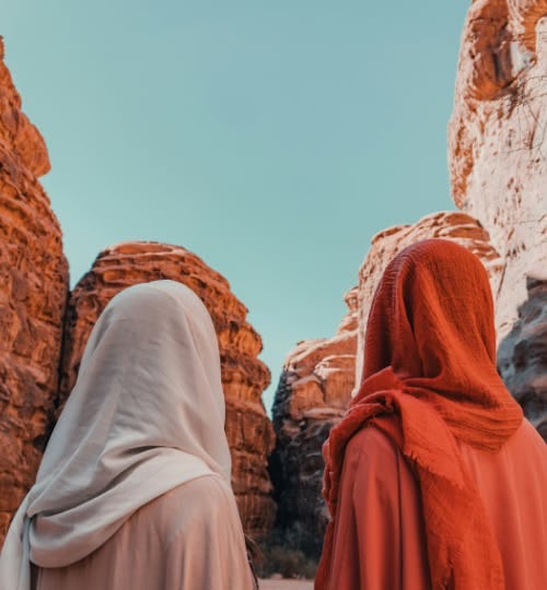 Two women looking at a rocky cliff in Saudi Arabia