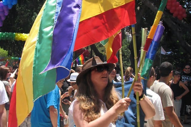 A crowed of people waving LGBT pride flags