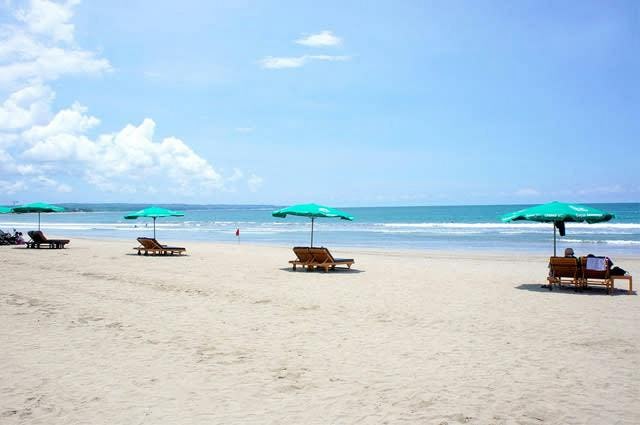 A sandy beach with sun loungers in Bali