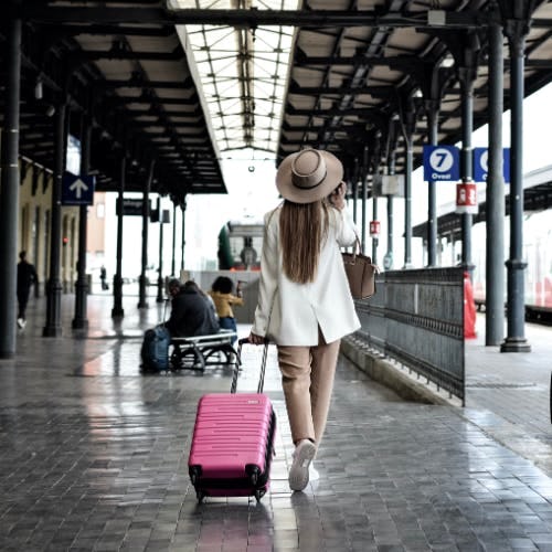 Women walking along with a pink suitcase