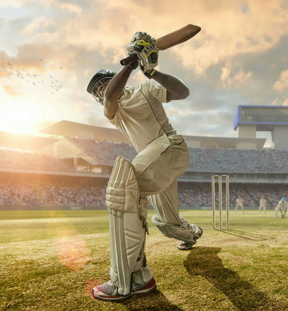 A cricket player swinging his bat on a cricket field