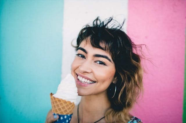 Woman eating icecream in front of Italian flag