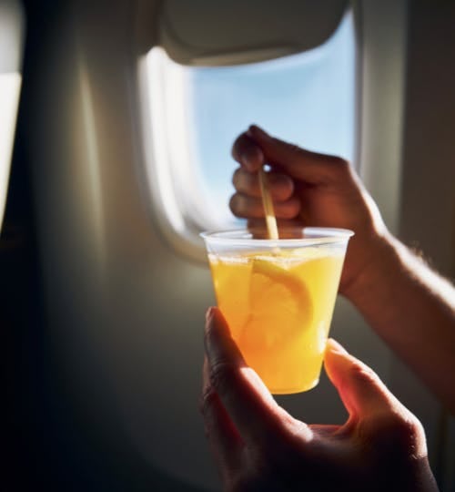 Man holding a mocktail while in flight