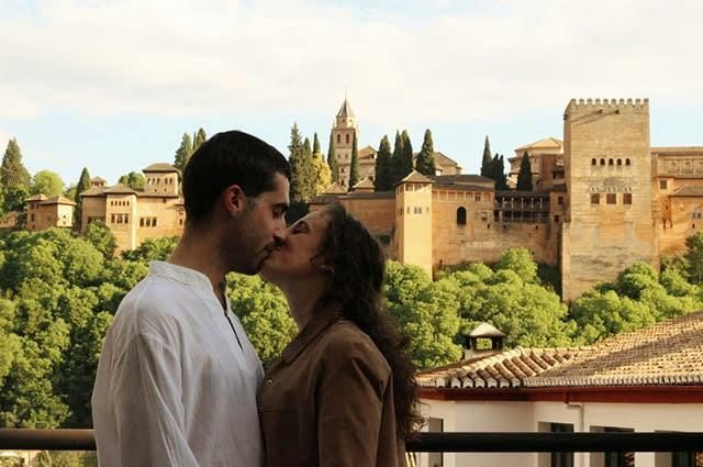 A couple kissing in front of a castle in Granada