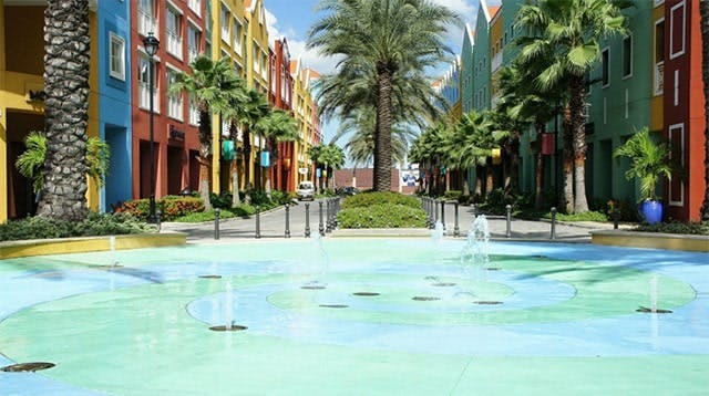A colourful street in Curacao with water feature and palm trees