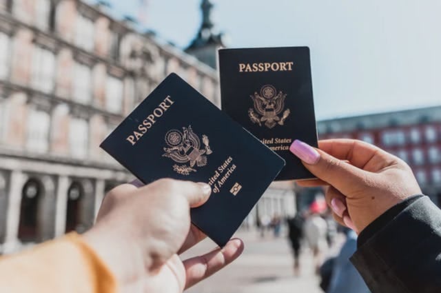 Man and women holding up 2 US passports