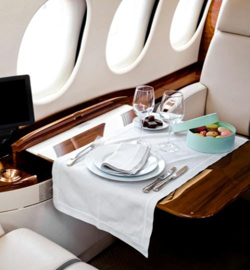 A business-class seat with cutlery on a table