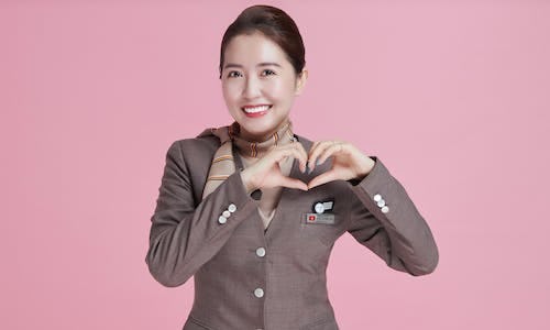 Asiana Airlines flight attendant with a pink background
