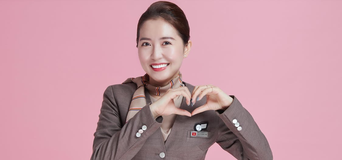 Asiana Airlines flight attendant with a pink background