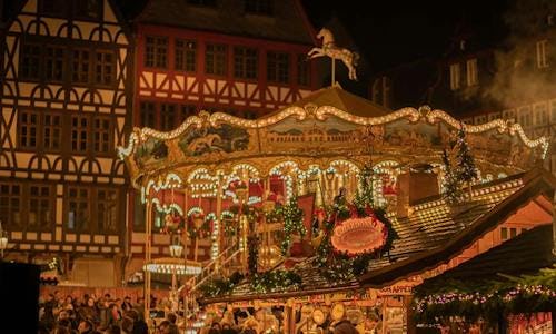 A picture of a carousel at a Christmas market during the night.