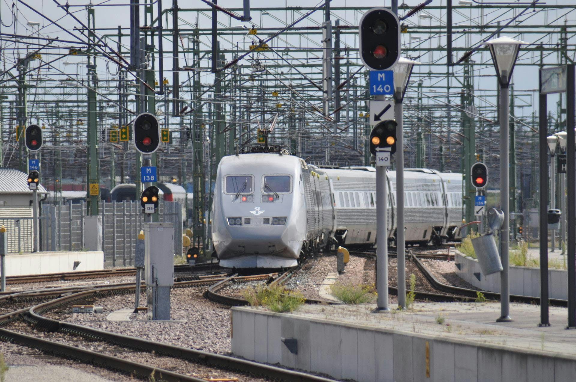 A silver SJ X2000 train departing the station