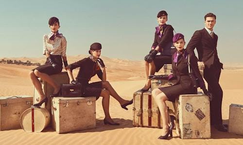 Etihad Airways crew sat on luggage in the Arabian desert