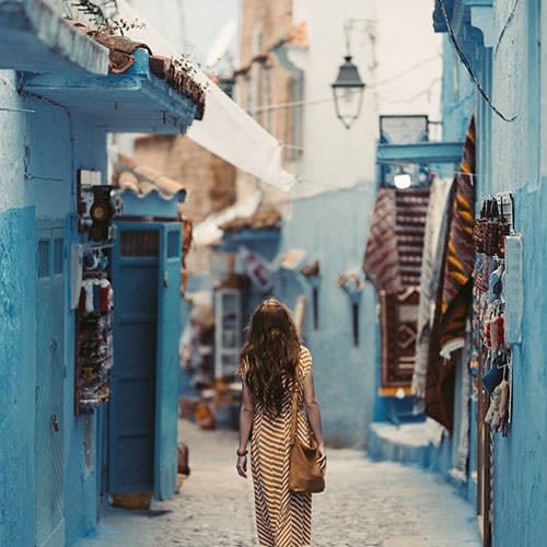 Woman walking down a cobblestone street