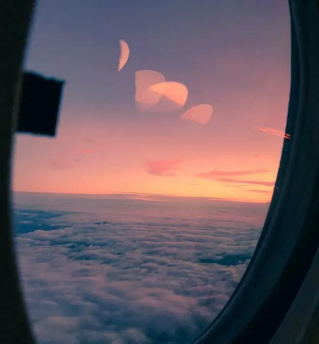 View out of an airplane window at sunset