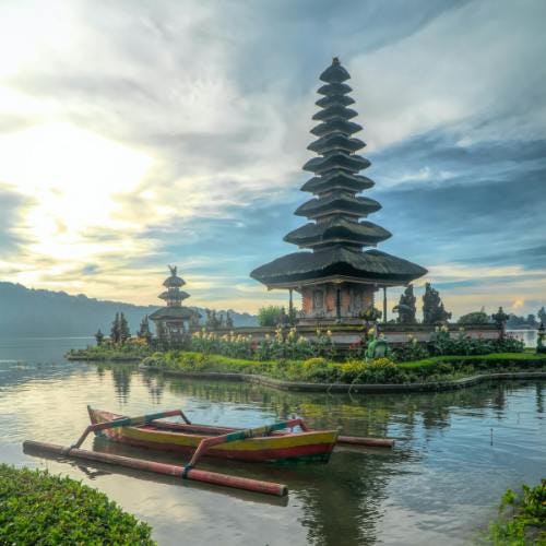 Bali temple surrounded by water with boat 