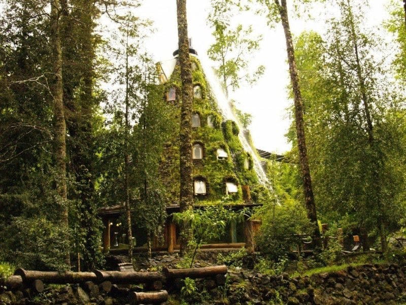 a rental accommodation called 'magic mountain'. The large domed wooden structure is covered in moss. 