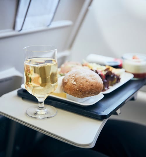 A glass of wine with an in-flight meal