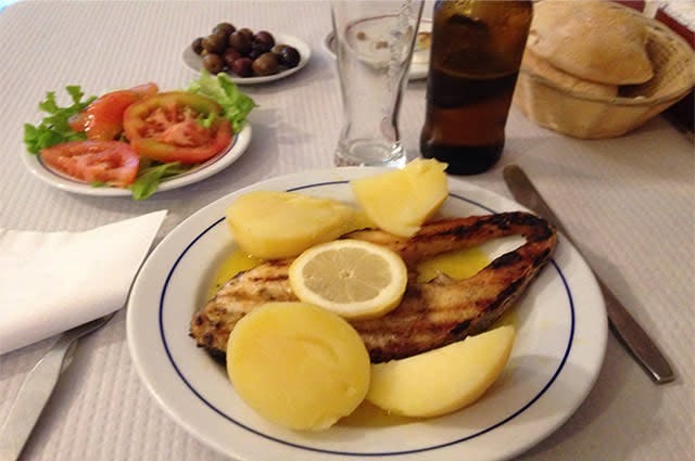 Image of a dinner in Italy featuring a chicken and potatoes and tomato side dish