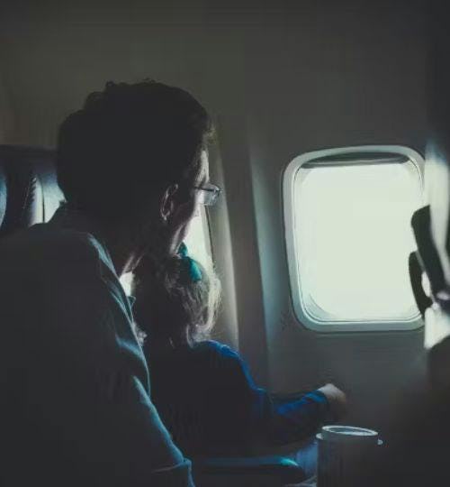 Father and Daughter looking out plane window