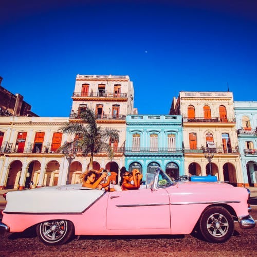 Group of girls in a pink car in Havana Cuba