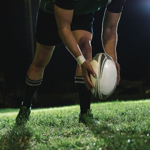 Man getting ready to kick a rugby ball