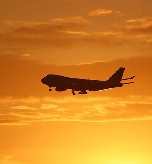 Airplane landing with sunset in background