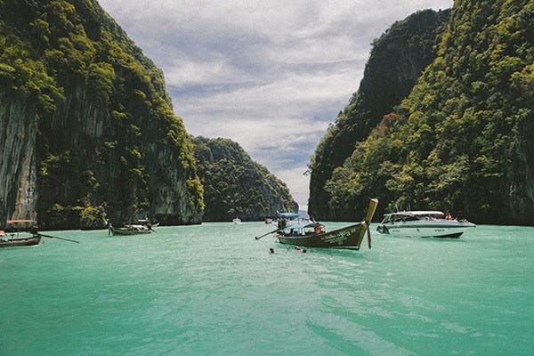 Picture of boats in the sea surrounded by mountains in Vietnam