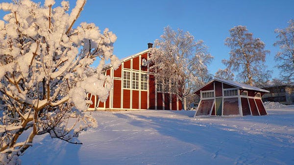 A traditional red Swedish house in a snow-covered Are 